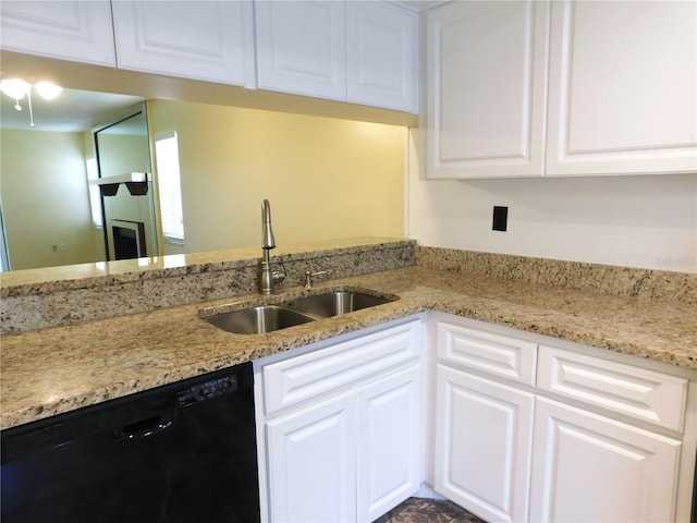 kitchen featuring light stone counters, sink, white cabinetry, and black dishwasher