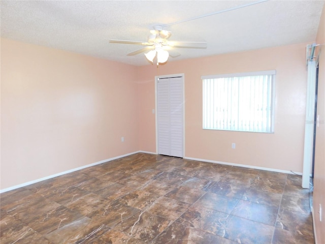 unfurnished room featuring ceiling fan and a textured ceiling