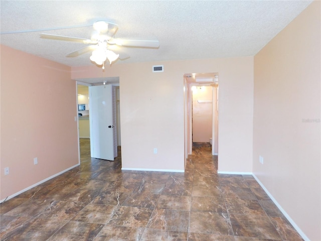 empty room with ceiling fan and a textured ceiling