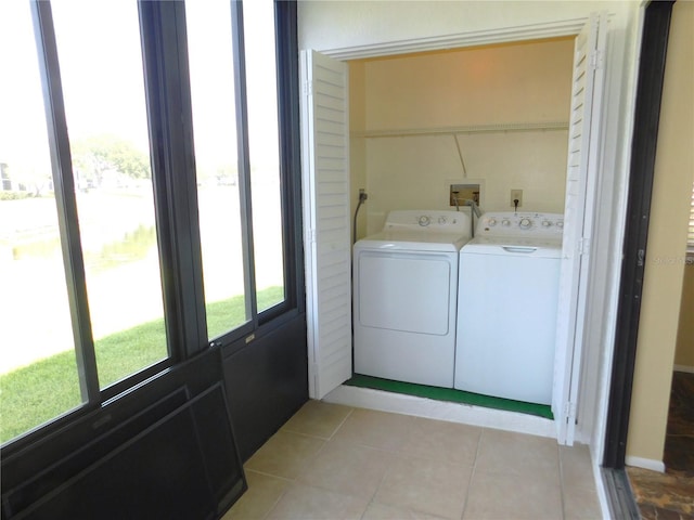 clothes washing area featuring independent washer and dryer and light tile patterned floors