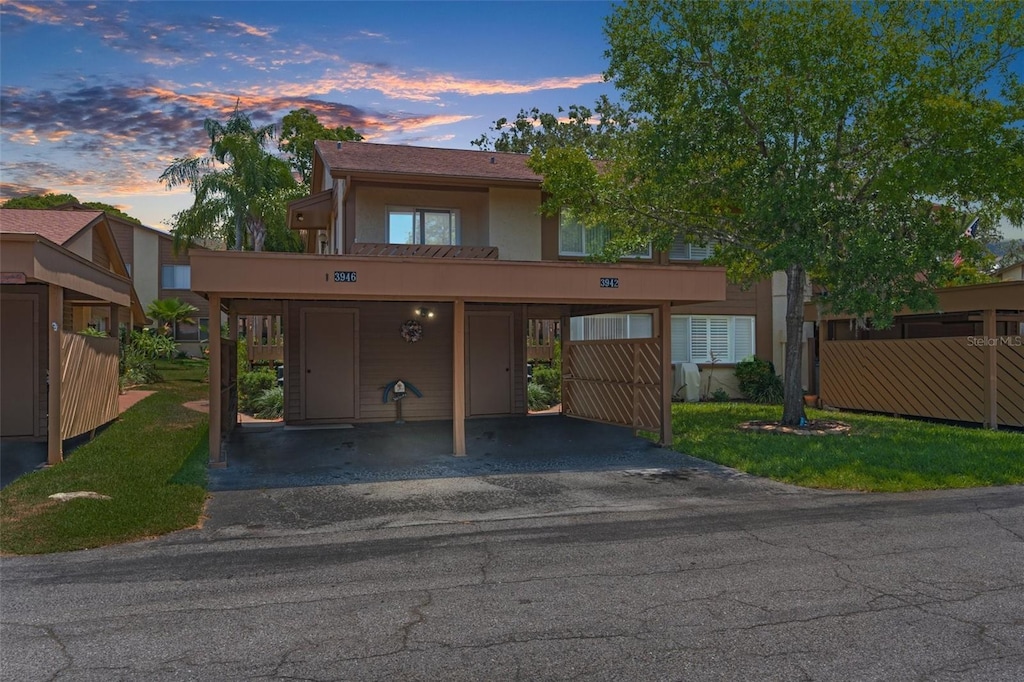 view of front of house with covered parking, fence, and stucco siding