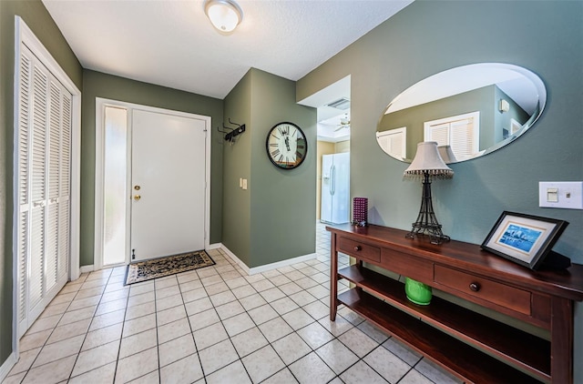 entryway featuring light tile patterned floors and ceiling fan