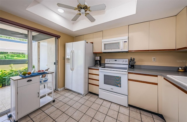 kitchen featuring ceiling fan, light tile patterned floors, a raised ceiling, white appliances, and white cabinets