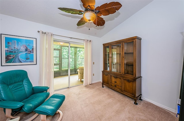 living area featuring ceiling fan, light colored carpet, and lofted ceiling