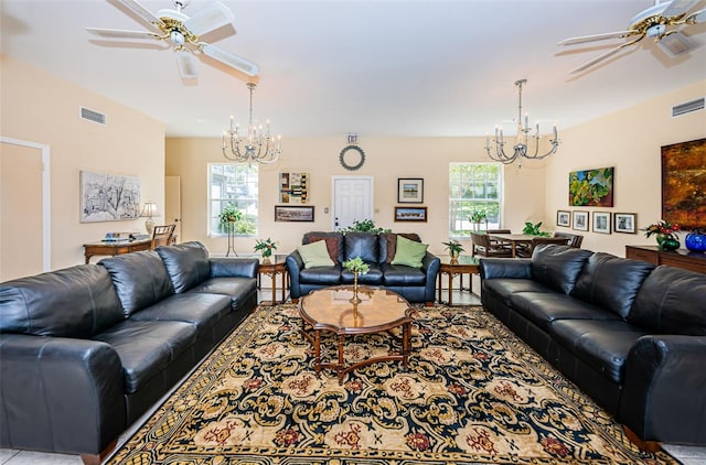 living room with ceiling fan with notable chandelier