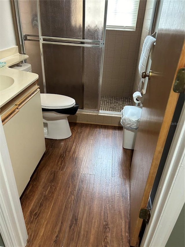 bathroom featuring hardwood / wood-style floors, vanity, an enclosed shower, and toilet