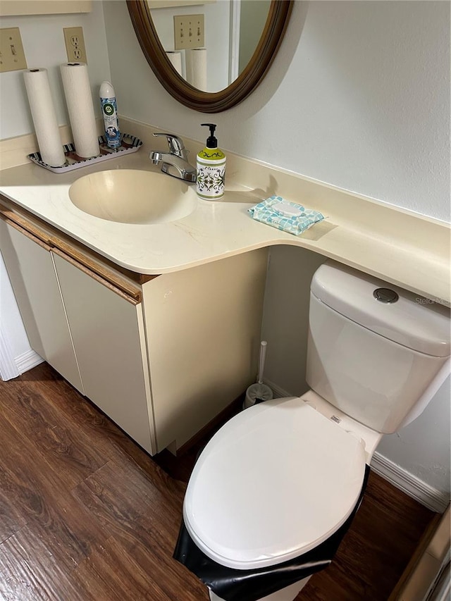 bathroom with hardwood / wood-style floors, vanity, and toilet