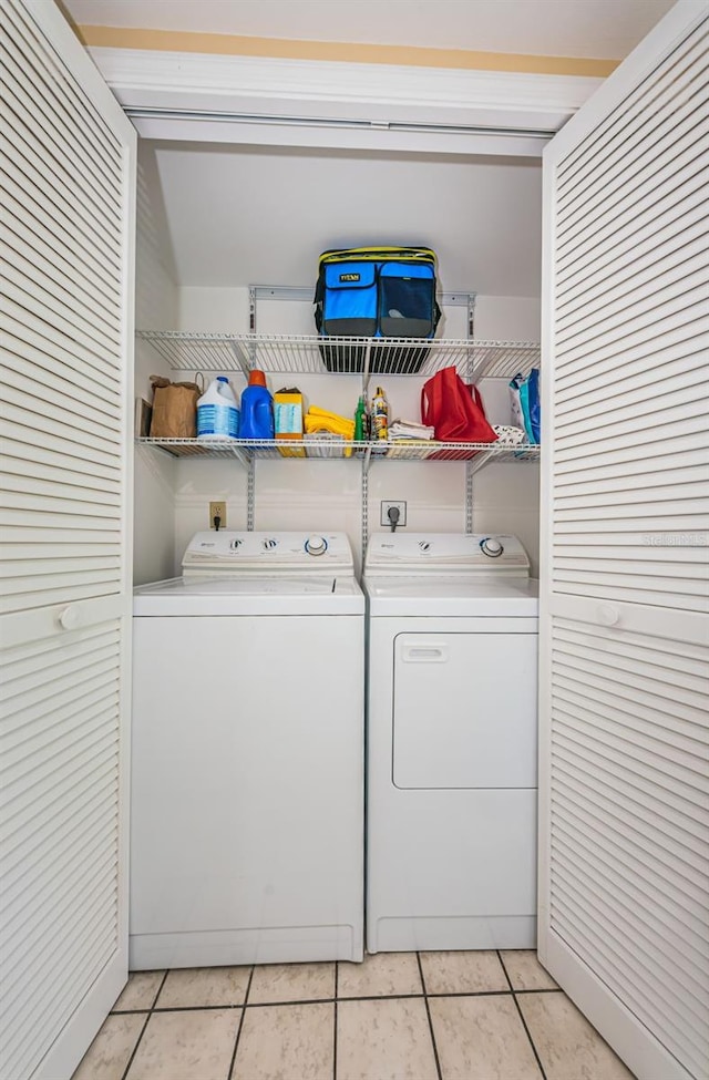 laundry room with washer and dryer and light tile patterned floors