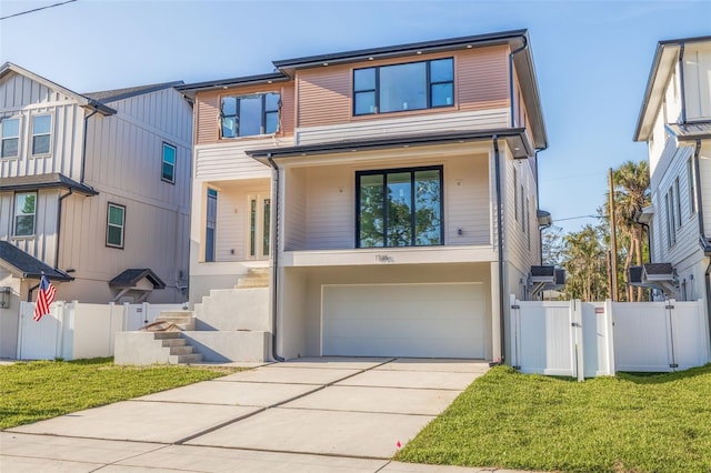 modern home featuring a front yard, a gate, fence, a garage, and driveway