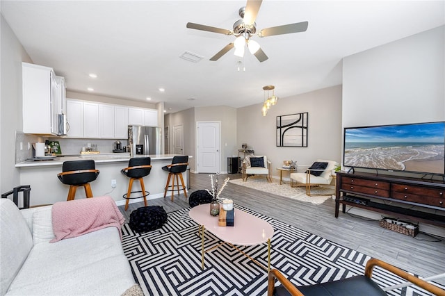 living room with ceiling fan and light hardwood / wood-style floors