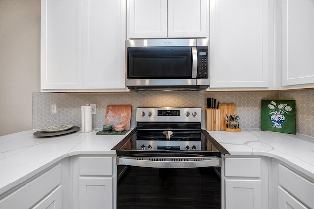 kitchen featuring decorative backsplash, white cabinetry, and stainless steel appliances