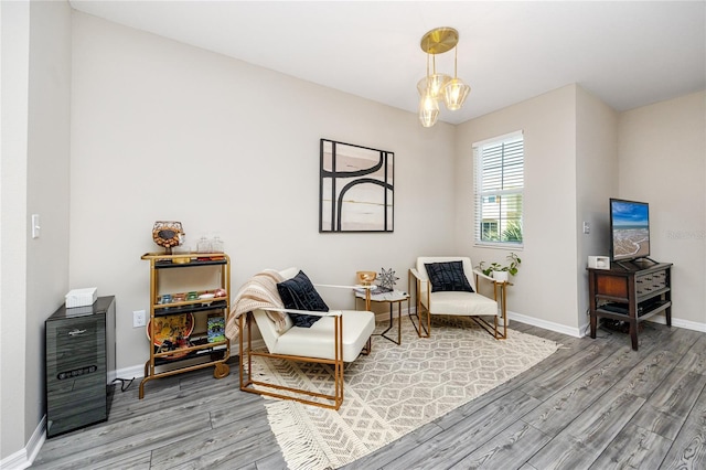 living area with hardwood / wood-style floors and a notable chandelier