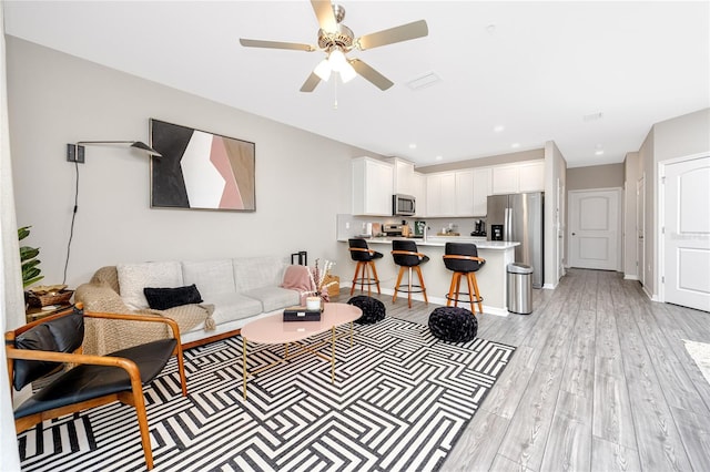 living room with ceiling fan and light hardwood / wood-style floors