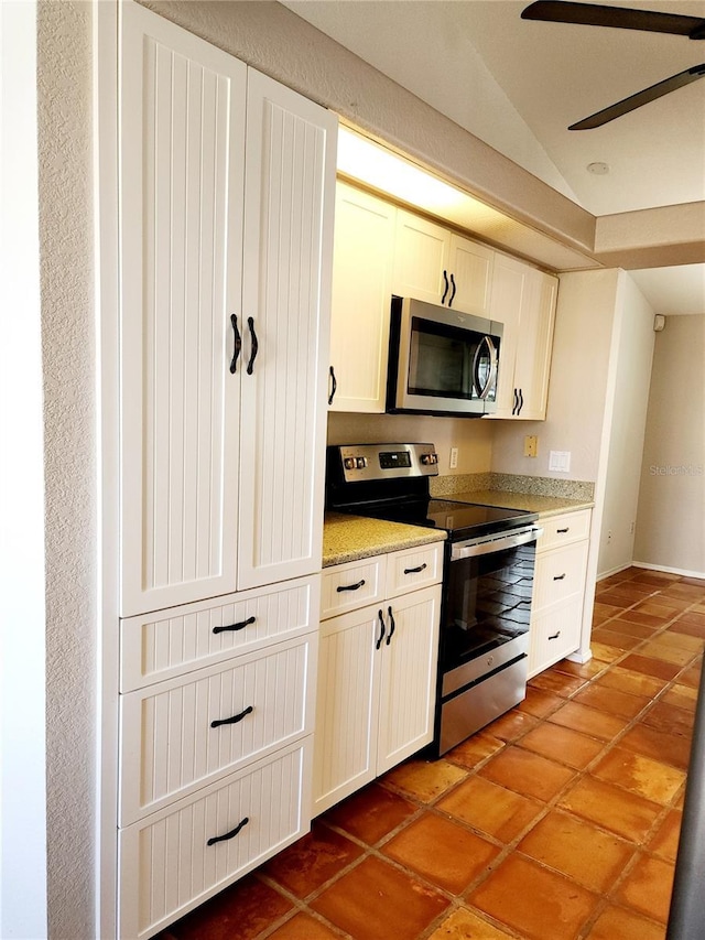 kitchen featuring lofted ceiling, white cabinets, tile patterned floors, ceiling fan, and appliances with stainless steel finishes