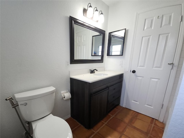 bathroom with tile patterned flooring, vanity, and toilet