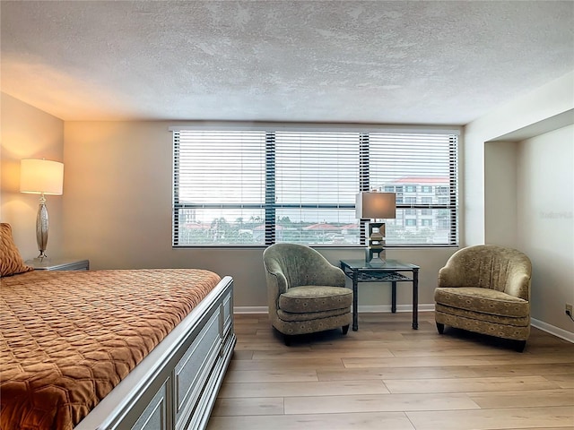 bedroom featuring light hardwood / wood-style flooring and a textured ceiling