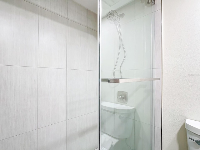 bathroom with an enclosed shower and toilet