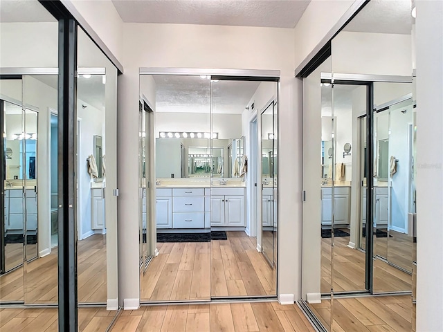 bathroom with vanity, wood-type flooring, and a textured ceiling