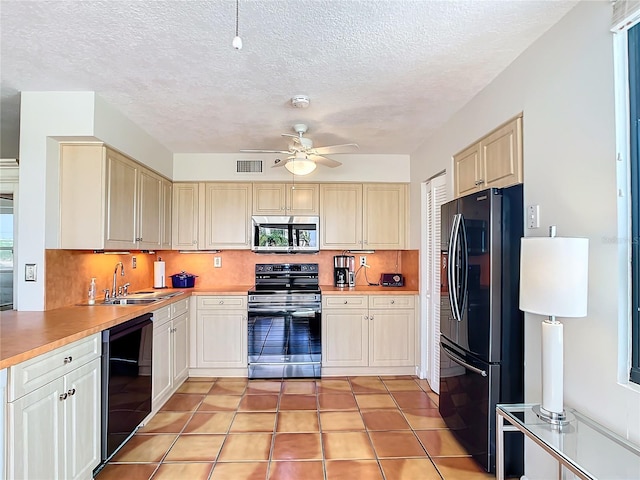 kitchen with sink, decorative backsplash, light tile patterned floors, ceiling fan, and black appliances