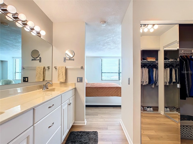 bathroom featuring wood-type flooring, a textured ceiling, and vanity