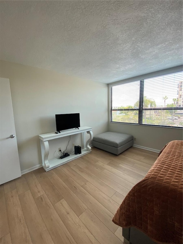 bedroom featuring light hardwood / wood-style floors and a textured ceiling