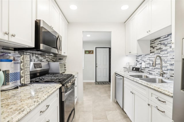 kitchen with white cabinets, sink, appliances with stainless steel finishes, and tasteful backsplash