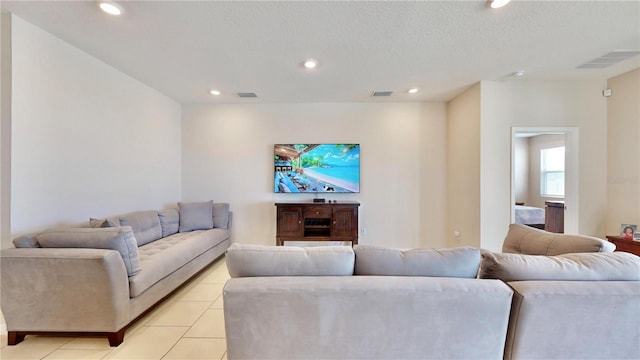 tiled living room featuring a textured ceiling