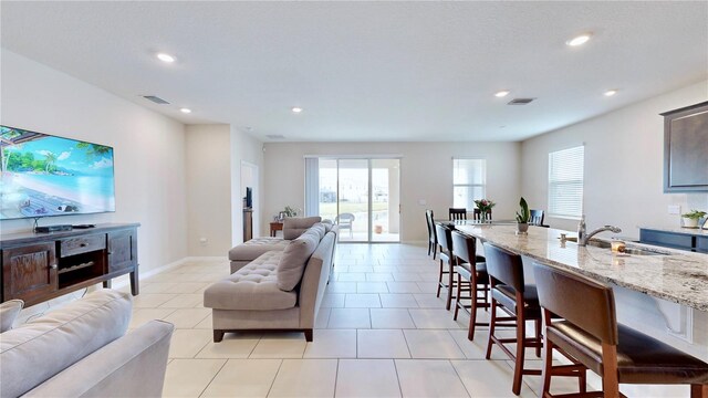 living room featuring sink and light tile floors