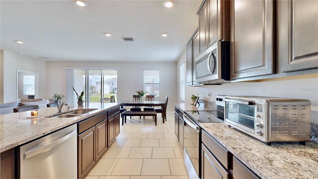 kitchen with stainless steel appliances, a wealth of natural light, sink, and light tile floors