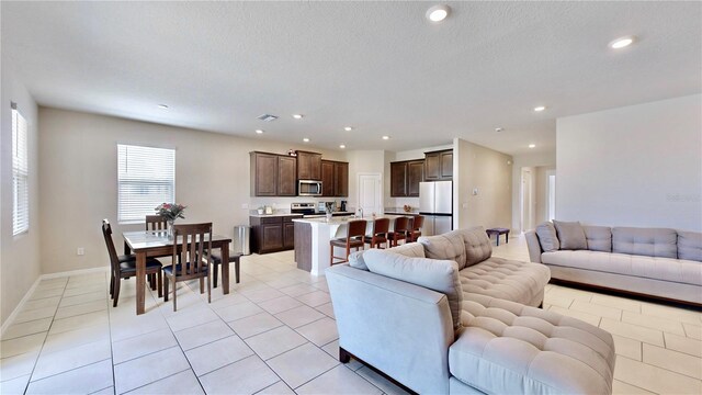 living room featuring a textured ceiling and light tile floors