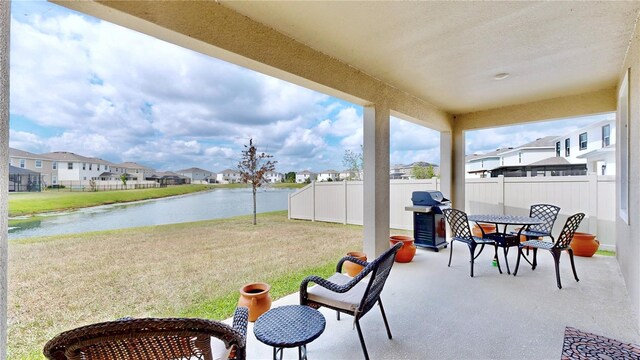 view of terrace featuring grilling area and a water view