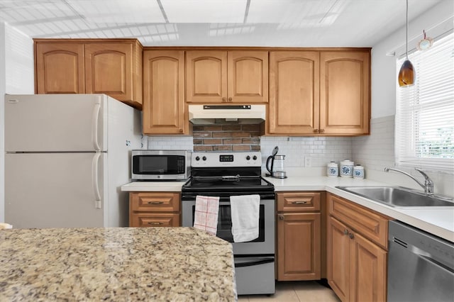 kitchen with appliances with stainless steel finishes, sink, tasteful backsplash, and light tile floors