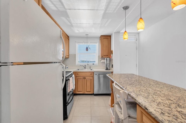 kitchen featuring stainless steel dishwasher, range with electric cooktop, pendant lighting, white fridge, and light tile floors