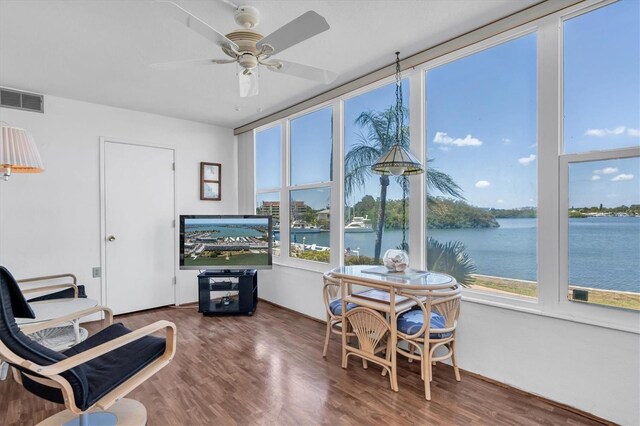 sunroom / solarium featuring a wealth of natural light, a water view, and ceiling fan