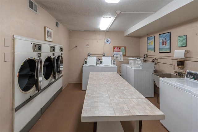 laundry area with washer and dryer and a textured ceiling