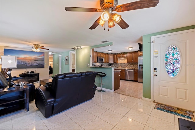 living area featuring visible vents, ceiling fan, and light tile patterned floors