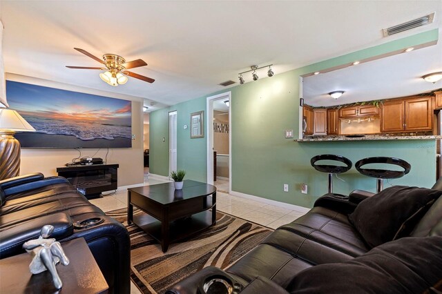 living room with ceiling fan, light tile patterned flooring, and rail lighting