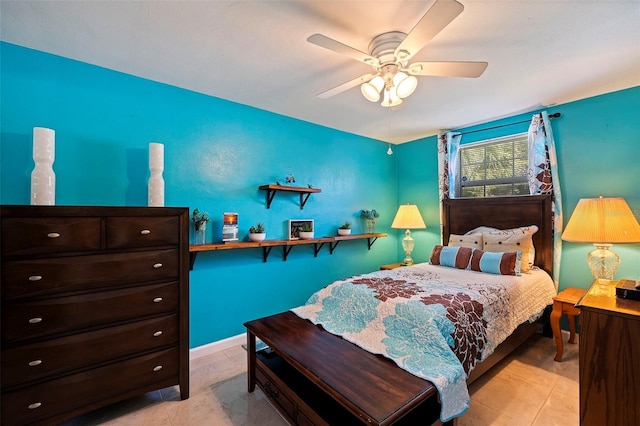 bedroom with light tile patterned flooring, a ceiling fan, and baseboards