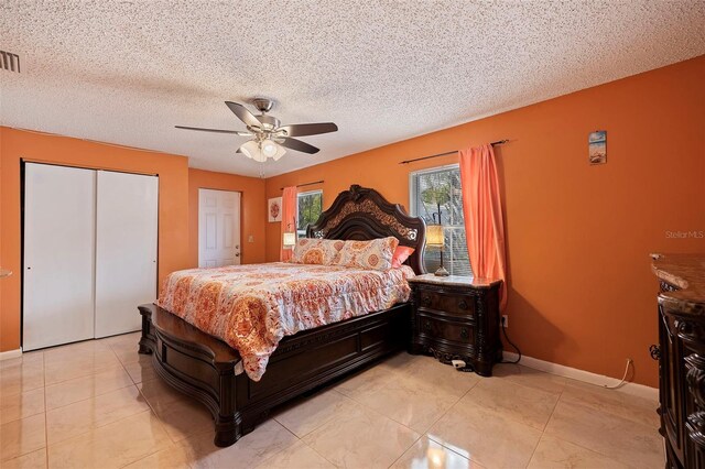 tiled bedroom with a textured ceiling and ceiling fan