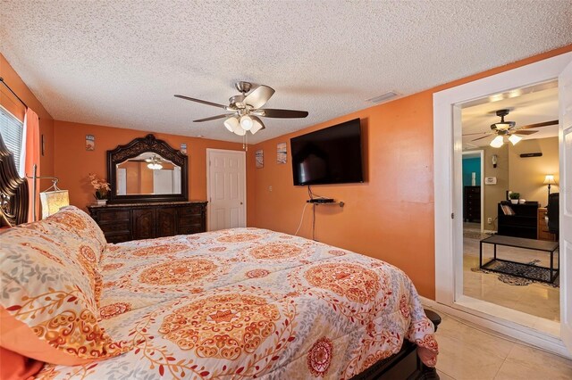 bedroom featuring a textured ceiling, ceiling fan, and light tile patterned flooring