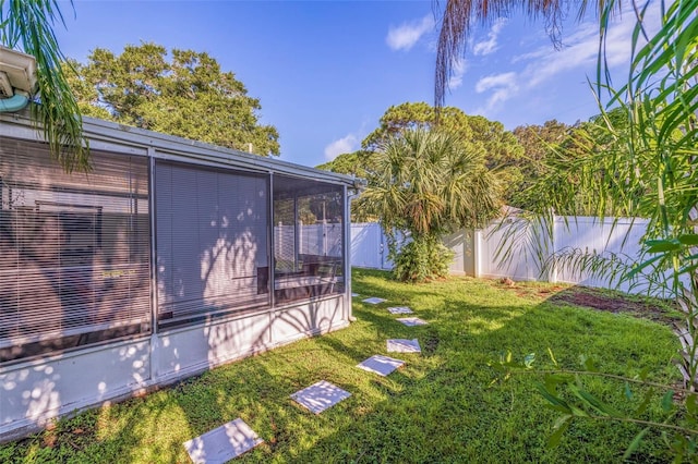 view of yard with a sunroom and a fenced backyard