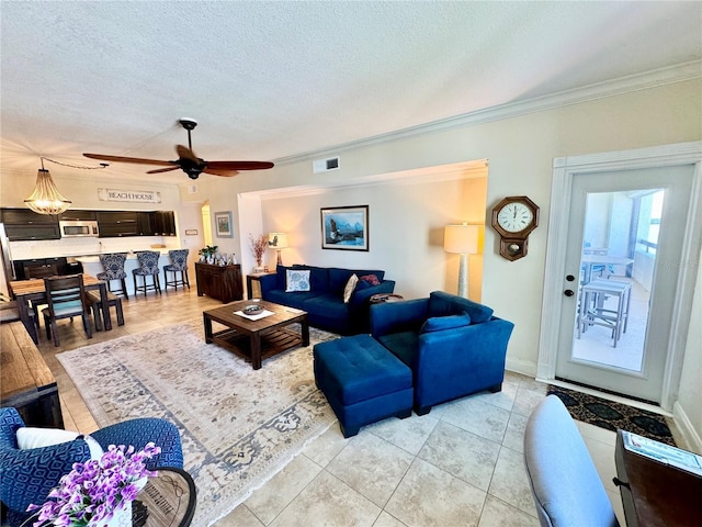 living room featuring ceiling fan, a textured ceiling, light tile patterned floors, and crown molding