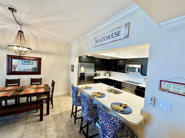 kitchen with appliances with stainless steel finishes, sink, hanging light fixtures, a notable chandelier, and light tile patterned floors