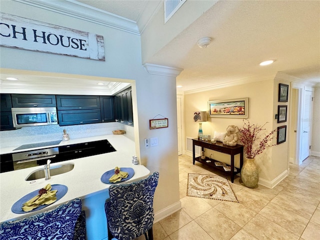 kitchen featuring light tile patterned floors, appliances with stainless steel finishes, a textured ceiling, crown molding, and sink