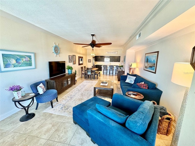 living room with ceiling fan, a textured ceiling, light tile patterned floors, and crown molding