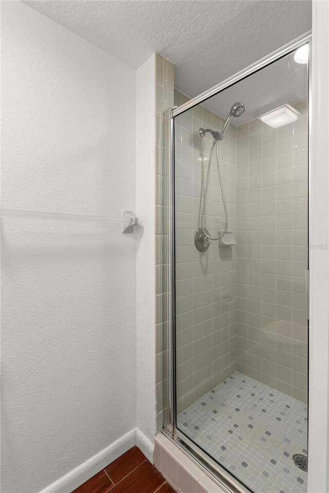 bathroom featuring a textured ceiling and an enclosed shower