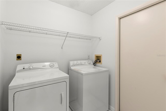 laundry area featuring separate washer and dryer and a textured ceiling