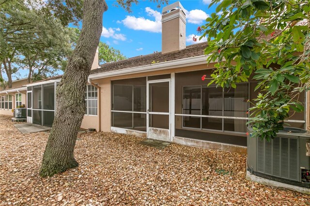 back of house with a sunroom and central AC unit