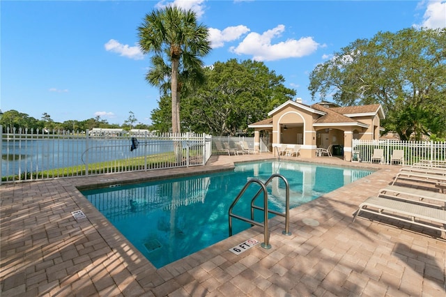 view of swimming pool featuring a water view and a patio