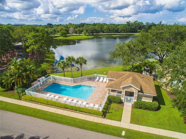 community pool with a water view and fence